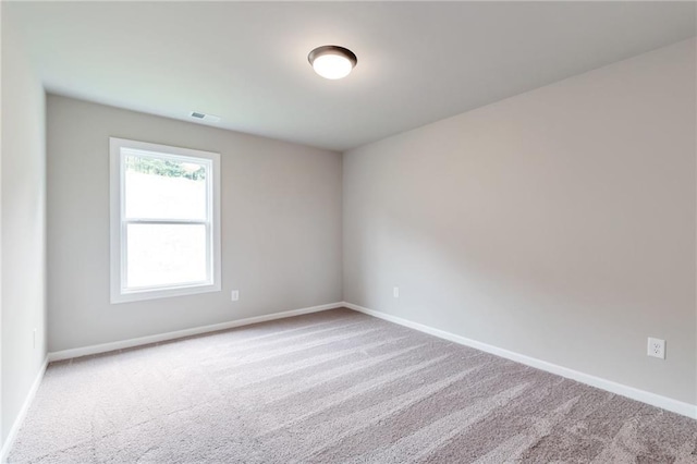 empty room with visible vents, baseboards, and carpet flooring