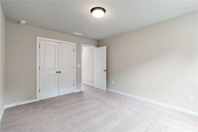 unfurnished bedroom featuring a closet, baseboards, and carpet floors