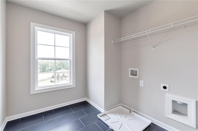 laundry room with electric dryer hookup, dark tile patterned floors, baseboards, hookup for a washing machine, and laundry area