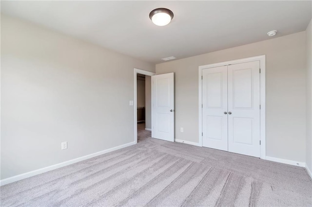 unfurnished bedroom with a closet, baseboards, and carpet floors