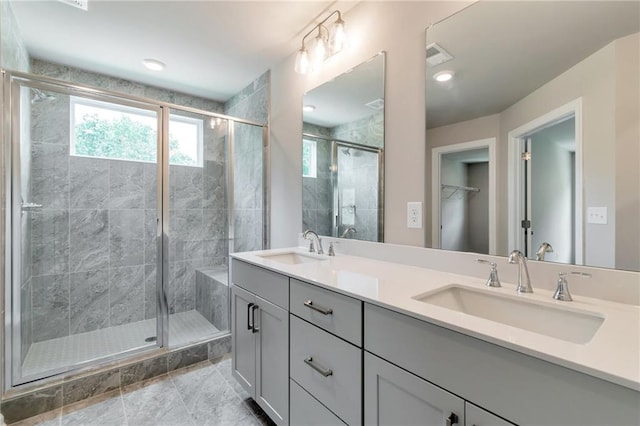 bathroom featuring double vanity, visible vents, a stall shower, and a sink