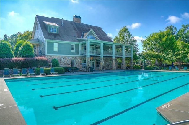 pool with a patio area and fence