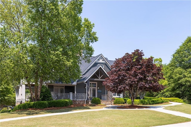 view of front of house featuring covered porch and a front yard