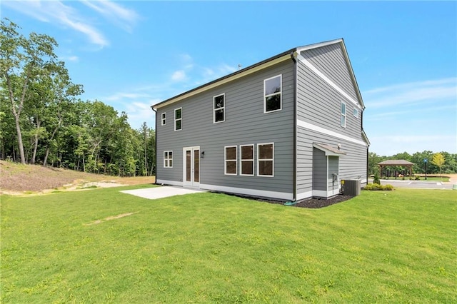 rear view of house featuring a patio, a lawn, and central AC