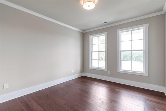 unfurnished room with dark wood-style floors, visible vents, crown molding, and baseboards