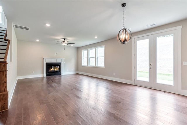 unfurnished living room featuring visible vents, stairway, and dark wood-style flooring