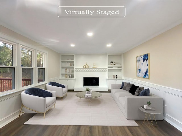 living room with wood-type flooring and built in shelves