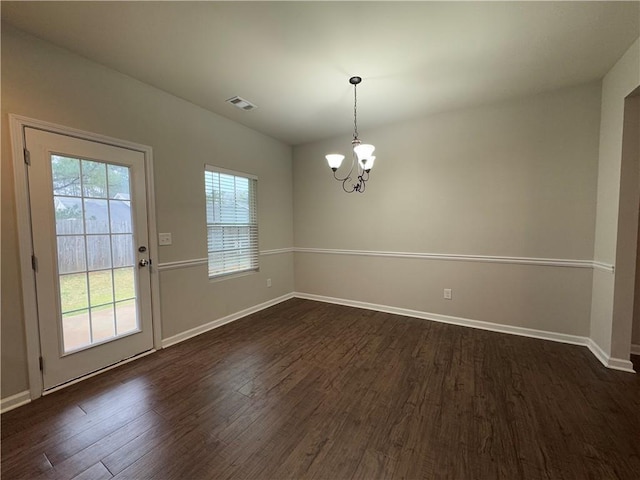 241 Coral Cir, Mcdonough, GA 30253 - unfurnished dining area featuring dark wood-type flooring and a chandelier