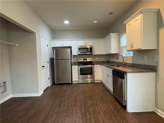 241 Coral Cir, Mcdonough, GA 30253 - kitchen with stainless steel appliances, dark wood finished floors, dark stone counters, white cabinets, and recessed lighting