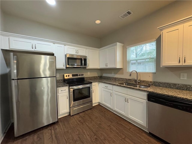 241 Coral Cir, Mcdonough, GA 30253 - kitchen featuring appliances with stainless steel finishes, dark wood finished floors, dark stone counters, white cabinets, and recessed lighting