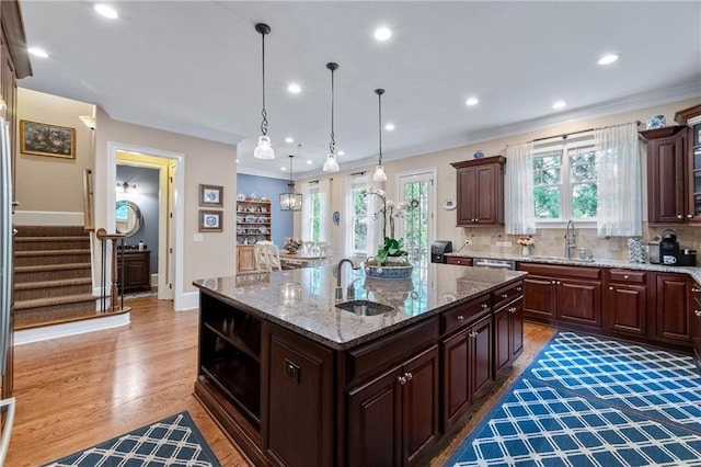 2283 Falmouth Ct SE Unit 22, Smyrna, GA 30080 - kitchen with an island with sink, ornamental molding, light wood-style floors, pendant lighting, and light stone counters