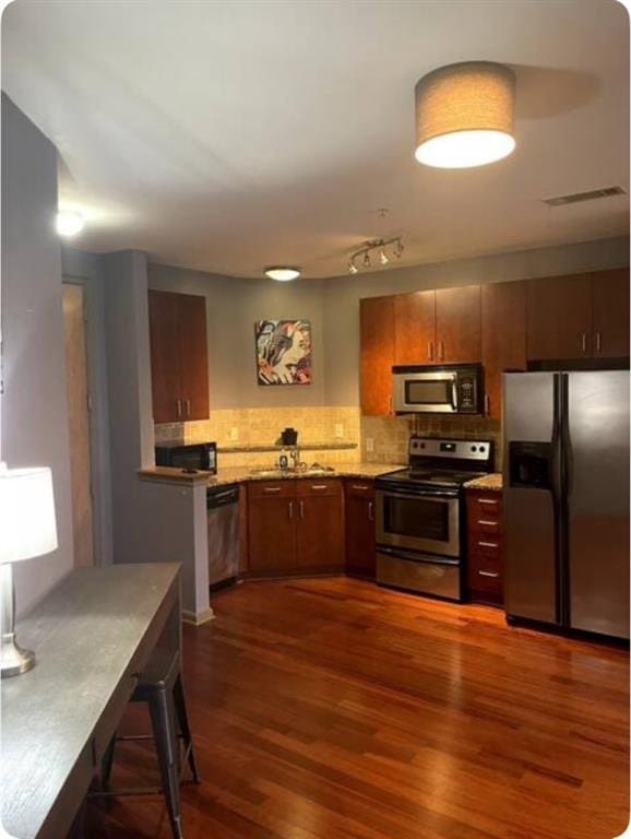 kitchen with stainless steel appliances, dark hardwood / wood-style floors, sink, and backsplash