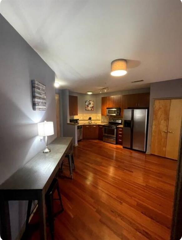 kitchen with stainless steel appliances and dark hardwood / wood-style flooring