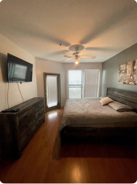 bedroom with dark hardwood / wood-style floors and ceiling fan