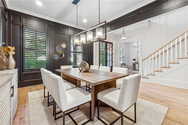 dining space featuring light hardwood / wood-style flooring and crown molding