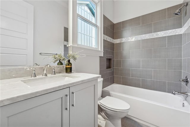 full bathroom featuring toilet, vanity, and tiled shower / bath