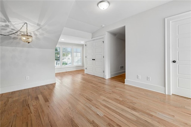 unfurnished living room with light hardwood / wood-style floors and lofted ceiling