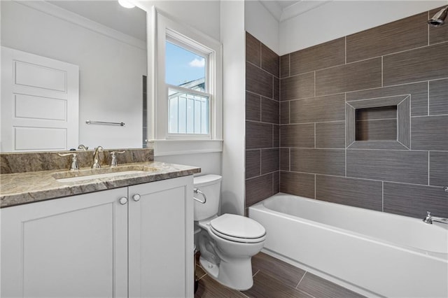 full bathroom with vanity, tiled shower / bath combo, crown molding, hardwood / wood-style floors, and toilet