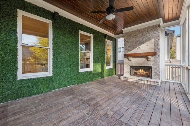 deck with an outdoor brick fireplace and ceiling fan