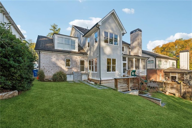 back of property featuring a sunroom and a yard