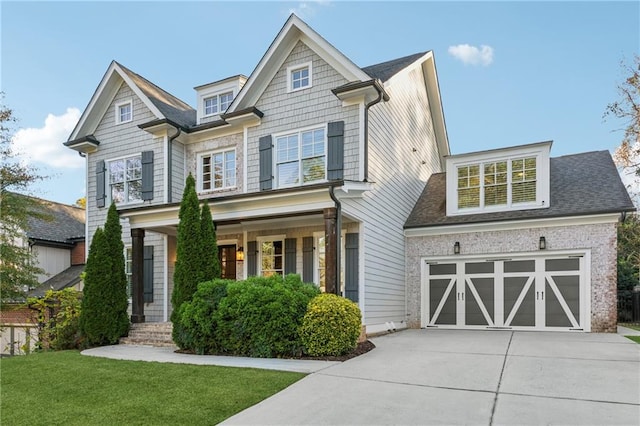 craftsman inspired home featuring a porch, a garage, and a front lawn