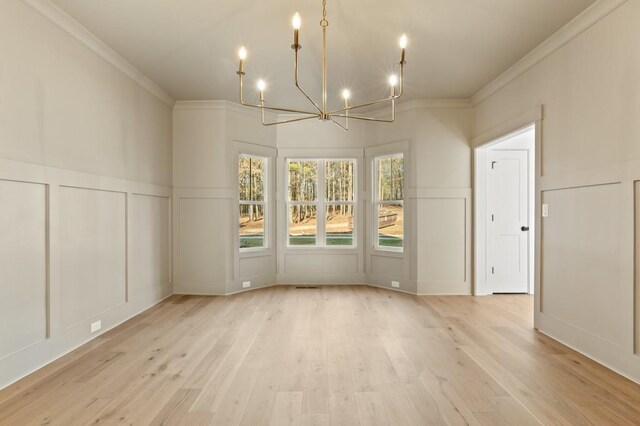 2410 Glade Overlook, Cumming, GA 30041 - unfurnished dining area with a decorative wall, ornamental molding, a chandelier, light wood-style floors, and a wainscoted wall