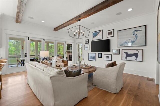 1141 Ragley Hall Rd NE, Brookhaven, GA 30319 - living room with beamed ceiling, wood finished floors, a chandelier, plenty of natural light, and crown molding