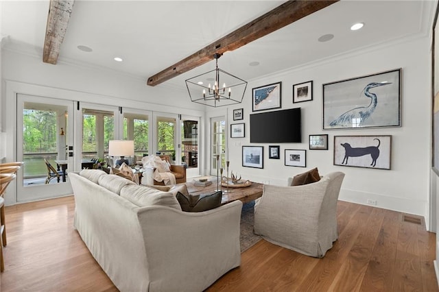 1141 Ragley Hall Rd NE, Brookhaven, GA 30319 - living area with a notable chandelier, wood finished floors, beam ceiling, and plenty of natural light