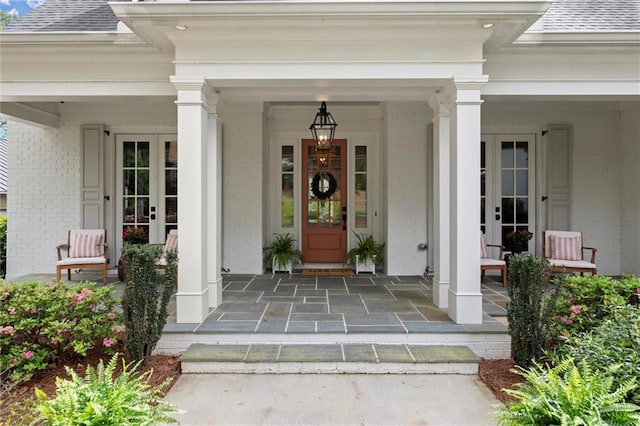 1141 Ragley Hall Rd NE, Brookhaven, GA 30319 - entrance to property featuring brick siding, french doors, a porch, and a shingled roof
