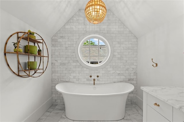 1141 Ragley Hall Rd NE, Brookhaven, GA 30319 - bathroom featuring a chandelier, marble finish floor, baseboards, a freestanding bath, and lofted ceiling