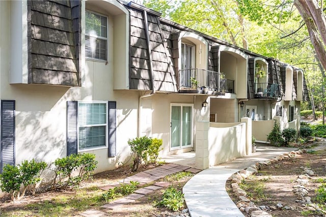 exterior space featuring a balcony and stucco siding