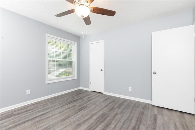 unfurnished bedroom with ceiling fan, baseboards, and wood finished floors