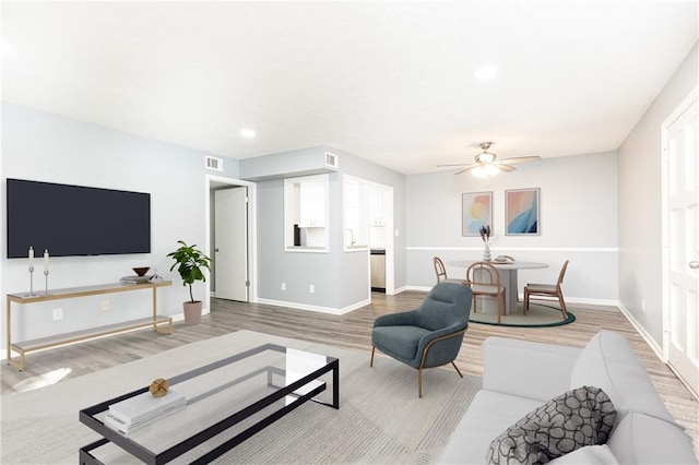 living area featuring visible vents, baseboards, ceiling fan, light wood-style floors, and recessed lighting