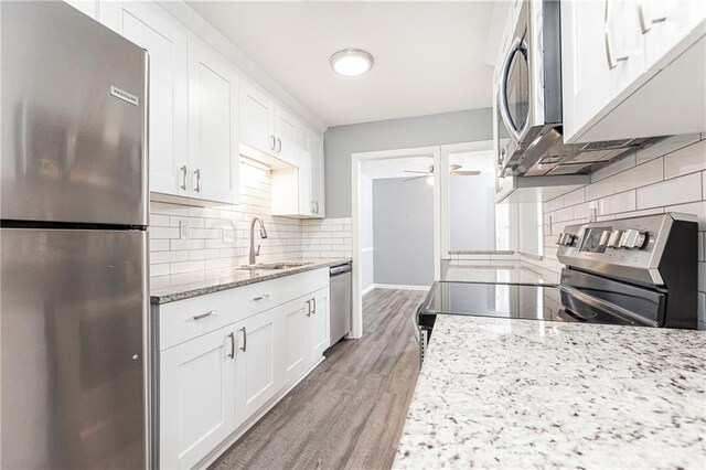 kitchen featuring tasteful backsplash, a sink, a ceiling fan, and appliances with stainless steel finishes