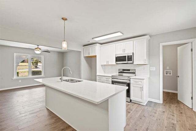 kitchen with white cabinets, a center island with sink, stainless steel appliances, and sink