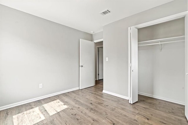 unfurnished bedroom with light hardwood / wood-style flooring and a closet