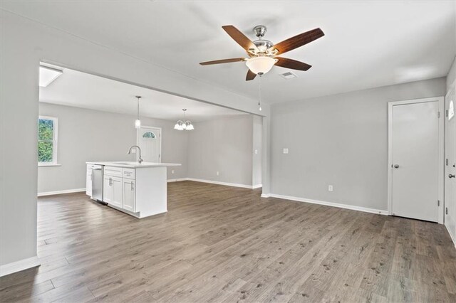 unfurnished living room featuring sink, hardwood / wood-style floors, and ceiling fan with notable chandelier