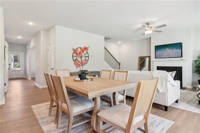 11113 Suria Dr, Covington, GA 30014 - dining room with stairs, light wood-type flooring, ceiling fan, recessed lighting, and a fireplace