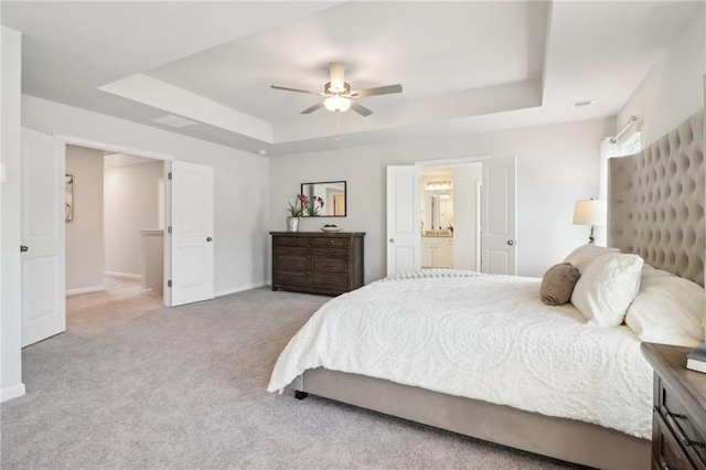 11113 Suria Dr, Covington, GA 30014 - carpeted bedroom with a tray ceiling, ceiling fan, and connected bathroom