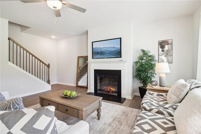 11113 Suria Dr, Covington, GA 30014 - living area featuring stairs, wood finished floors, ceiling fan, a glass covered fireplace, and recessed lighting