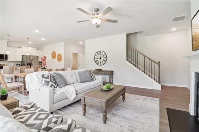 11113 Suria Dr, Covington, GA 30014 - living area with stairway, wood finished floors, ceiling fan, recessed lighting, and a fireplace