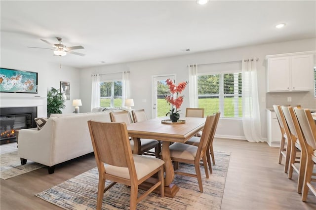 11113 Suria Dr, Covington, GA 30014 - dining area featuring light wood-style flooring, recessed lighting, a glass covered fireplace, and ceiling fan