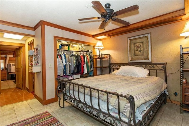 bedroom featuring ceiling fan, ornamental molding, light tile patterned floors, and a closet