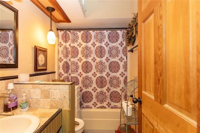 full bath featuring vanity, shower / bath combo with shower curtain, and toilet