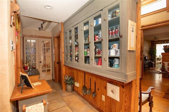 interior space featuring french doors, a textured ceiling, and tile patterned floors