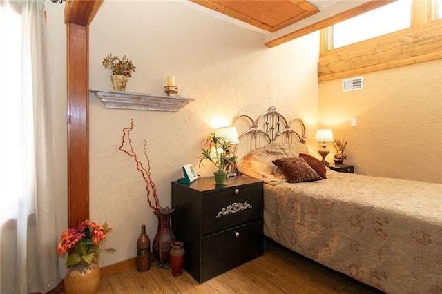 bedroom with visible vents and wood finished floors