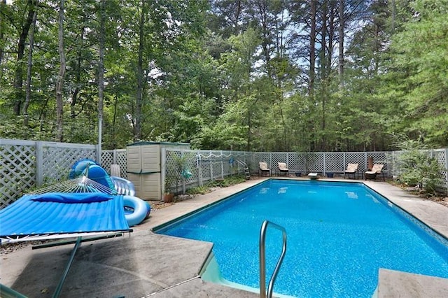 view of pool featuring a fenced in pool, a fenced backyard, a diving board, and a patio
