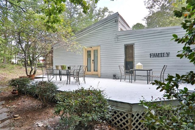 back of property featuring a wooden deck, french doors, and outdoor dining space