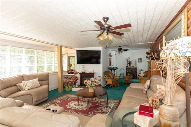 living area featuring plenty of natural light, carpet, and a ceiling fan