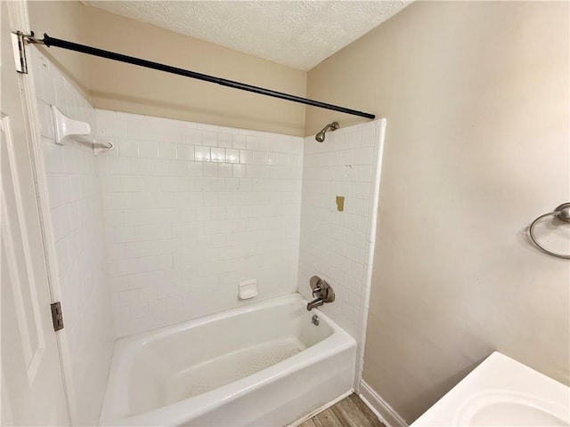 bathroom with wood-type flooring, shower / washtub combination, and a textured ceiling